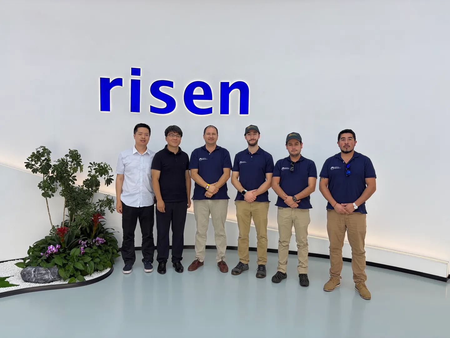Seis personas posan frente al logotipo de Risen; cuatro llevan polera de EERGYGROUP.